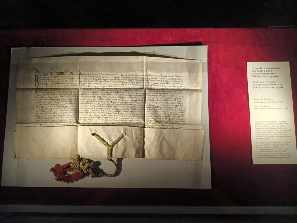 Historic parchment manuscript with handwritten Latin text and seal on a red display background, illustrating the Ancient Library of Alexandria